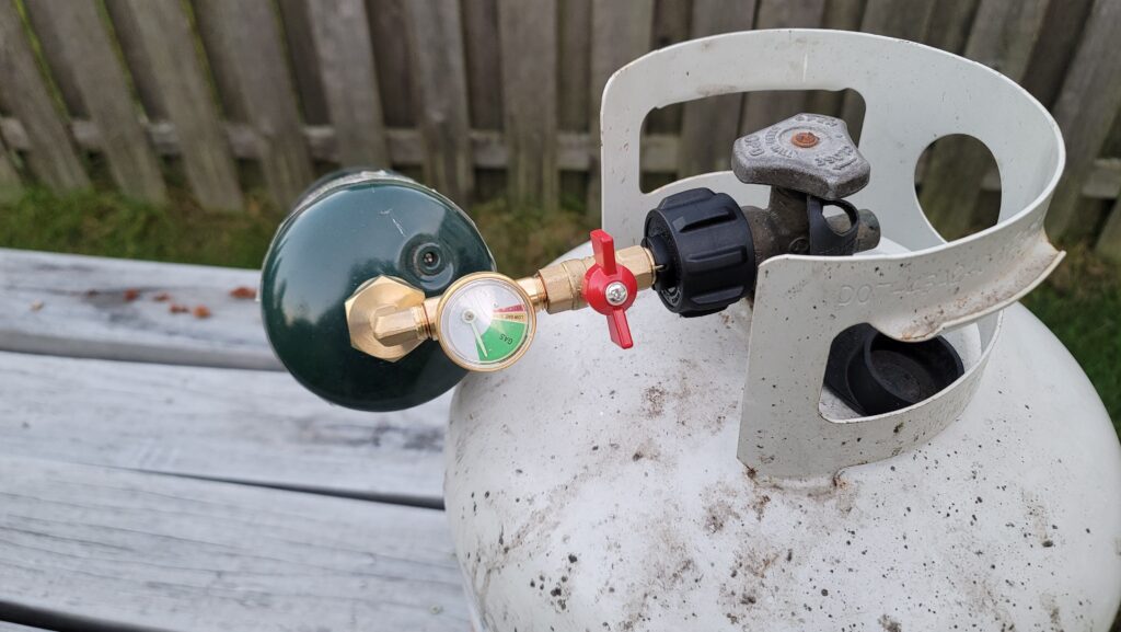 Quick fill adapter connected to large and small propane canisters